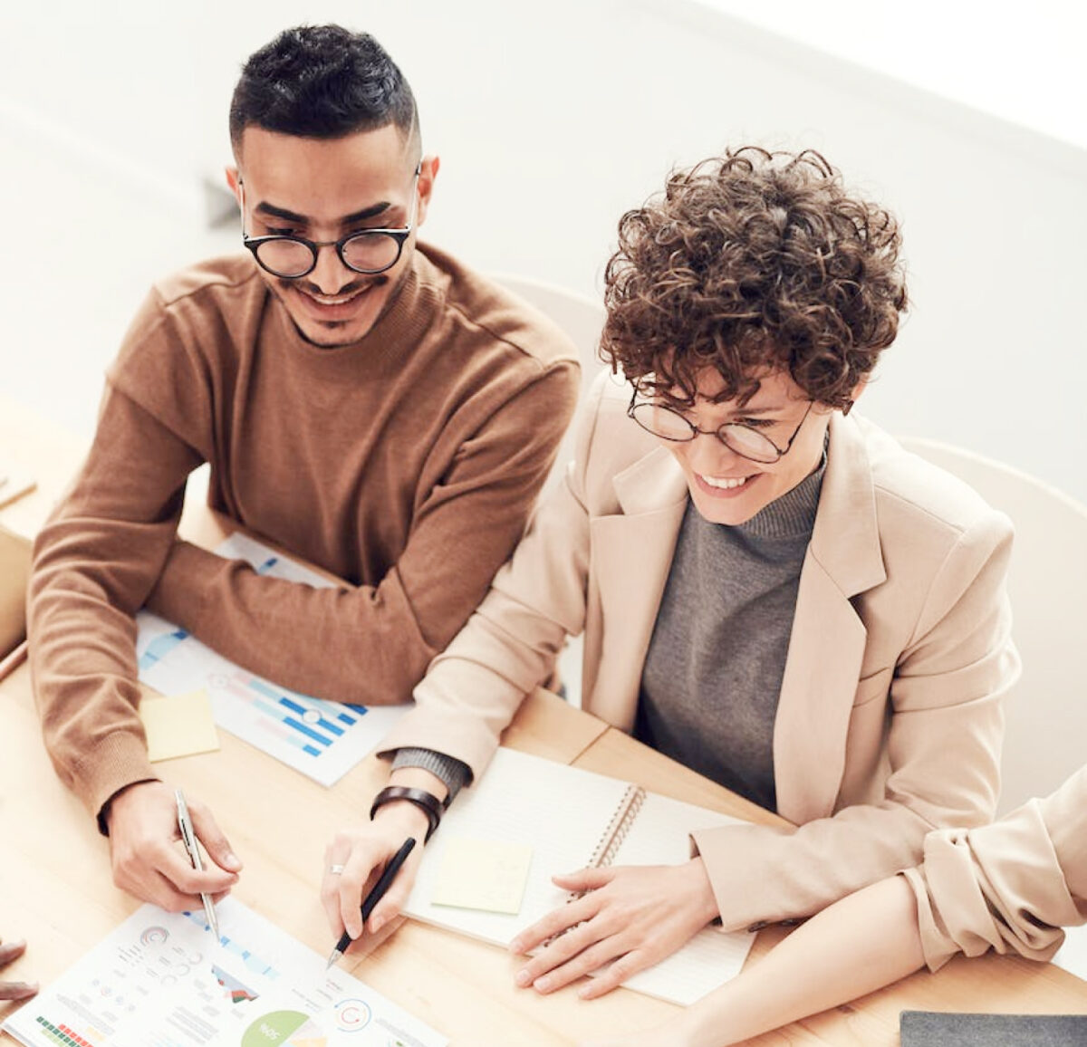 Two people looking at papers on work table